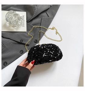 Detail of black sequin evening bag with gold chain strap against a grey blazer background