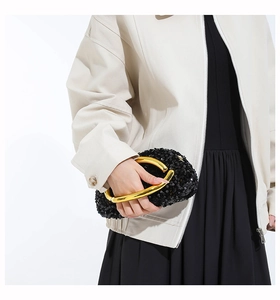 Detail of black sequin evening bag featuring a chunky gold metal ring handle