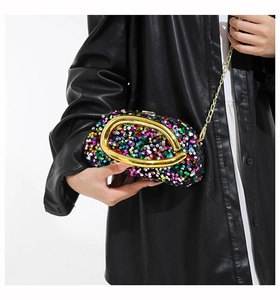 Detail of colorful sequin evening clutch bag with chunky gold metal U-handle and chain strap