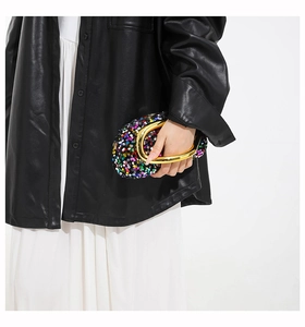 Detail of colorful sequined evening bag with a thick gold-toned metal handle