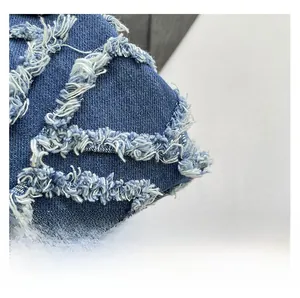 Macro shot of blue and white twill denim fabric with distressed frayed fringe details