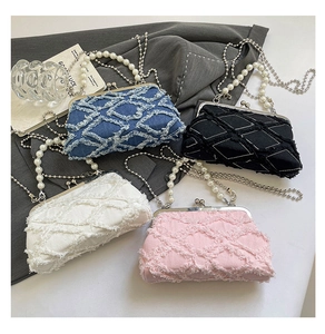 Detail of vintage denim clutch bags with quilted stitching and pearl chain straps