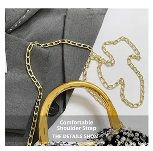 Detail of glitter sequins surface with gold metal ring handle and luxury chain strap