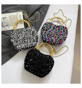 Detailed shot of three heart-shaped sequin evening bags in black, silver, and rainbow colors