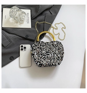 Detail of silver sequin crossbody evening bag with gold metal handle and chain strap