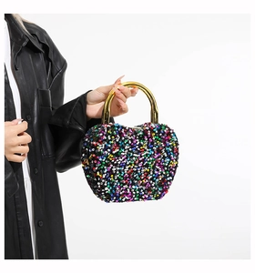 Detail of colorful sequins and golden metal handle on the luxury fashion handbag