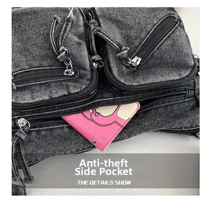 Détail d'un sac bandoulière en denim noir délavé avec une poche latérale antivol à fermeture éclair