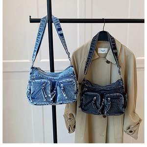 Détail de sacs bandoulière en denim lavé vintage en bleu et gris avec poches utilitaires