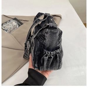 Détails du tissu en denim délavé et de la fermeture éclair d'un sac à bandoulière décontracté
