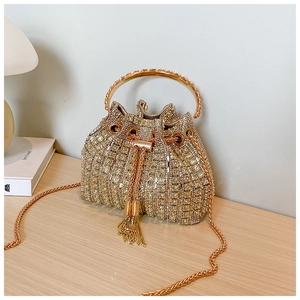 Close-up of golden rhinestone bucket bag with tassel drawstring and metal handle