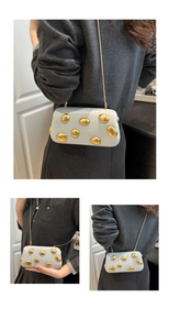 Détail du sac bandoulière bleu clair avec clous dorés et fine bandoulière chaîne