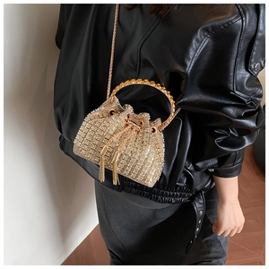 Detail of evening bucket bag with gold rhinestones, metal handle and tassel drawstring