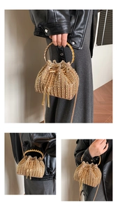 Detailed view of sparkling golden rhinestone bucket bag with metal fringe and round handle