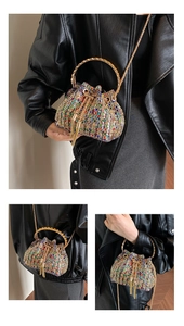 Detail of multi-color rhinestone bucket bag with gold ring handles and tassel drawstring