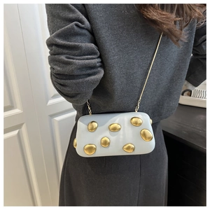Détail du sac boîte bleu clair avec accents métalliques dorés et une bandoulière chaîne