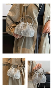 Detailed view of silver rhinestone bucket bag featuring metal ring handle and crystal tassels