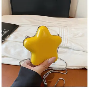 Detail of yellow star-shaped mini lipstick bag with silver chain and glossy finish