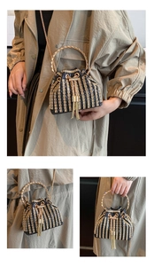 Detail of evening bucket bag with gold rhinestone stripes, metal ring handle and tassel