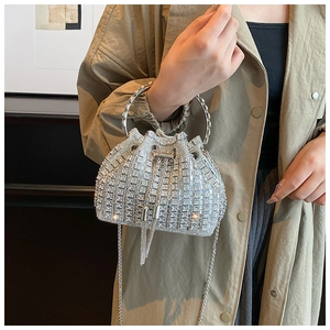 Close-up of a silver rhinestone bucket bag featuring a drawstring tassel and metal handle