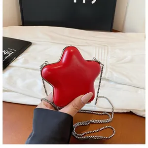 Detailed close-up of a red star-shaped crossbody bag with a silver chain strap