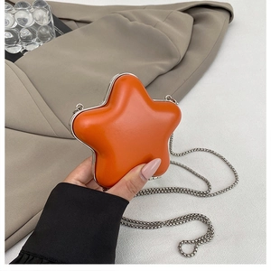 Close-up of star-shaped mini crossbody bag in orange gloss finish with silver chain