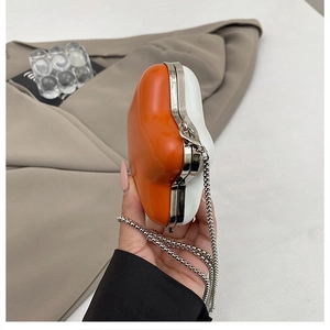 Detail of orange and white star-shaped mini bag with silver chain and metal frame