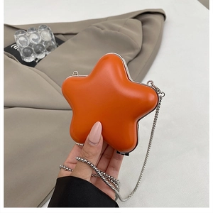 Macro shot of orange star-shaped mini bag with silver metal trim and chain