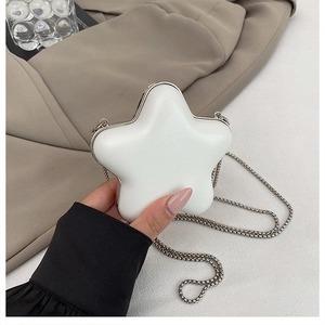 Macro detail of star-shaped mini lipstick bag with silver trim and metal chain strap
