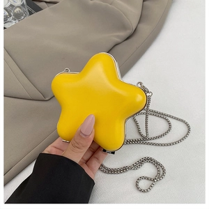Detail of a yellow star-shaped mini chain bag with silver metallic trim and glossy finish