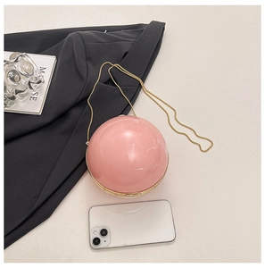 Detail of pink spherical acrylic evening bag with gold trim and chain strap