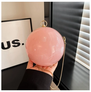 Close-up of pink acrylic spherical evening bag with gold chain and ring clasp detail