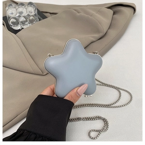 Close-up of a star-shaped mini crossbody bag with a silver chain and metal frame