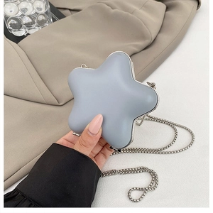 Detail of grey star-shaped mini clutch with silver metal frame and elegant chain strap
