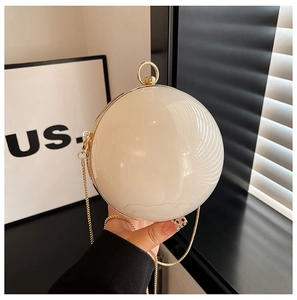 Detailed view of spherical acrylic evening bag with gold metal handle and pearl finish