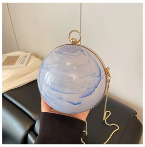 Detail of blue and white marble acrylic spherical evening bag with gold ring handle