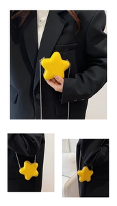 Detail of yellow star-shaped mini crossbody bag with silver chain and glossy finish