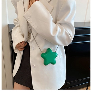 Detailed view of a mini star-shaped crossbody bag in green with a slim silver chain strap