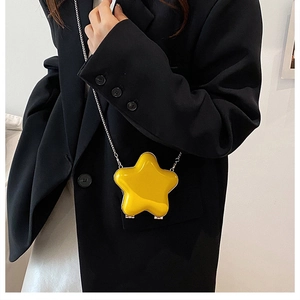 Macro view of bright yellow star-shaped mini crossbody bag with silver metal chain