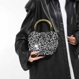 Silver sequin heart-shaped evening bag with a gold round handle and chain strap