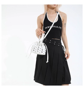 On-body view of white bucket bag with silver studs and thin shoulder strap