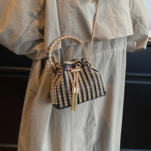 Chic rhinestone bucket bag with gold ring handle and black striped sequin finish