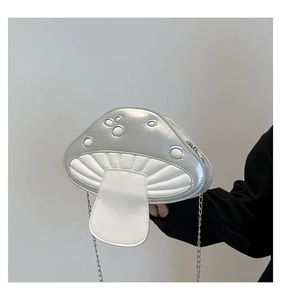 Detail der kreativen Pilz-Umhängetasche mit silberner Metallic-Oberfläche und Punktmuster