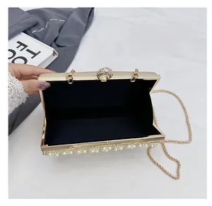 Detailansicht der goldenen Glitzer-Clutch mit Perlenbesatz und offenem Innenraum