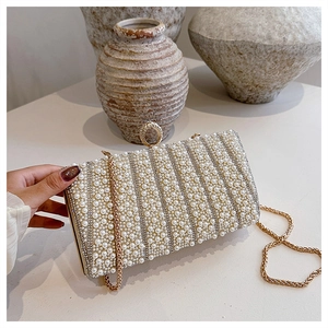 Detailansicht der luxuriösen Abendtasche mit Perlen, Strass und goldener Kette