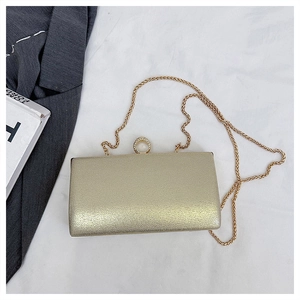 Detailsicht einer goldenen Abendtasche mit Glitzer-Finish, Ringverschluss und Kette