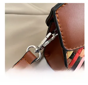 Detail of silver metal hook and vibrant colorful woven leather pattern on the handbag