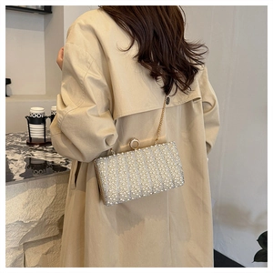 Detailansicht der Luxus-Abendtasche mit Perlenbesatz und goldenem Kettenriemen für Damen