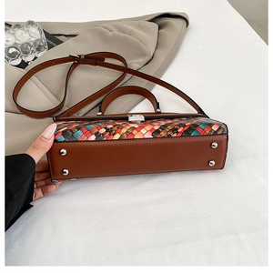 Détail du motif tissé coloré et des pieds de protection sur un sac fourre-tout marron