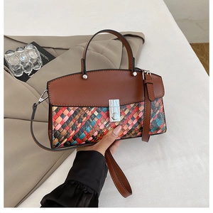 Detail of multi-color woven crossbody bag featuring contrast leather flap and silver buckle