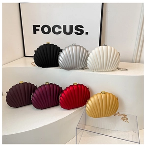 Detail of shell-shaped acrylic evening bags in various colors on display stands